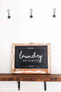 a sign that says laundry wash dry and fold hanging on a wall above a shelf