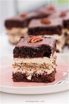 a piece of cake with pecans on top is sitting on a plate next to the rest of the cake