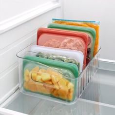 four plastic containers with food in them are on the refrigerator's door shelf, ready to be packed