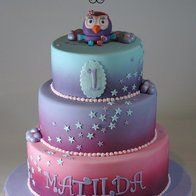 a three tiered cake decorated with an owl on top and stars around the edges