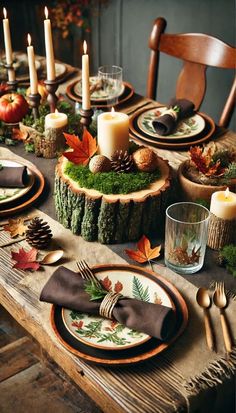 a wooden table topped with plates covered in fall leaves and pineconies next to candles