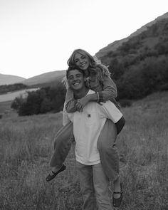 a man carrying a woman on his back in a field