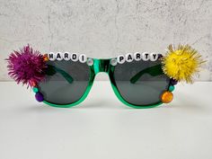 a pair of sunglasses decorated with pom - poms