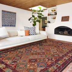 a living room filled with furniture and a rug on top of a hard wood floor