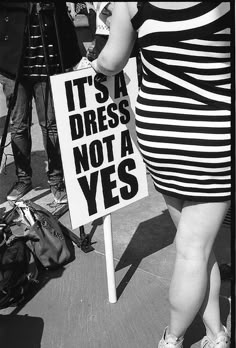 a woman holding a sign that says it's a dress not a yes