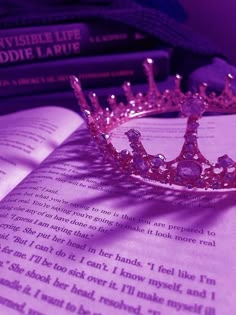 a pink tiara sitting on top of an open book