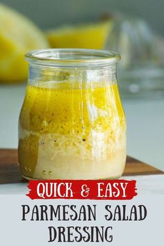 a jar filled with parmesan salad dressing on top of a cutting board