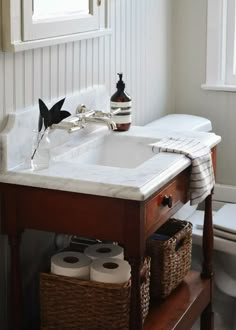 a bathroom sink with two rolls of toilet paper on the counter next to it and a window