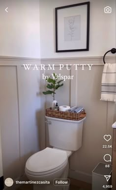 a white toilet sitting in a bathroom next to a wooden cabinet and sink with a mirror above it