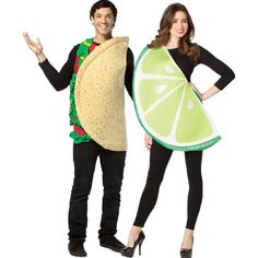 a man and woman dressed in costumes standing next to each other, one holding a slice of lime