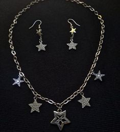 This one-of-a-kind jewelry set features eye-catching star charms that truly set them apart. This set contains the perfect accessories to enhance your outfit! Works well with any y2k style outfit. *Chain length is 19 1/2 inches Y2k Style Outfits, Y2k Necklace, Star Charm Necklace, Y2k Jewelry, Star Charms, Silver Stars, Y2k Style, Chain Lengths, Chain Length