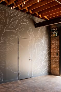 an empty room with a door and brick wall in the background is decorated with white flowers