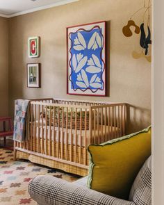 a baby's room with a couch, crib and pictures on the wall