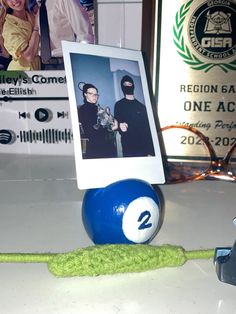 a pool ball with a photo on it and a green string attached to the end