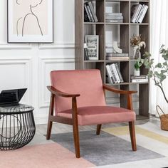 a pink chair sitting in front of a book shelf