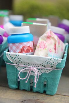 a basket filled with baby items sitting on top of a wooden table covered in lace