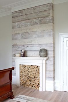 the fireplace is made out of wood and has a white mantle with logs on it