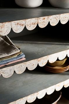 an old metal shelf with plates and bowls on it