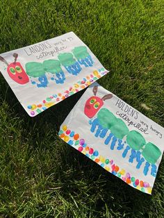 two children's paper kites sitting in the grass