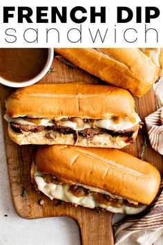 french dip sandwiches on a cutting board with sauce