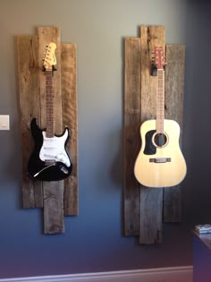 two guitars are hanging on the wall next to each other, one is made out of pallet wood