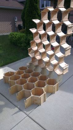 several wooden boxes stacked on top of each other in front of a building with a bicycle parked next to it