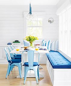 a dining room table with blue chairs and a bench