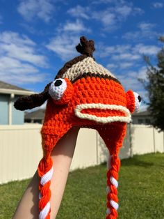 someone is holding up a crocheted hat that looks like a fish on it