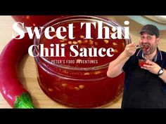 a man holding a spoon in front of a jar of chili sauce with the words sweet thai chili sauce