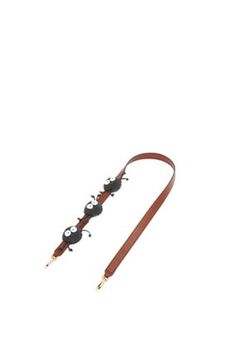 a brown leather leash with metal fittings on the end and two black beads hanging from it