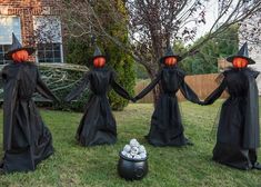 three people dressed in black holding hands and wearing halloween costumes with pumpkins on their heads