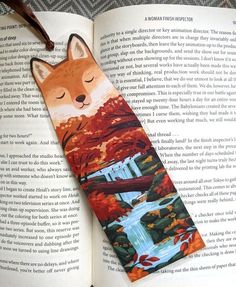 a bookmark with an image of a fox in the woods on it's side