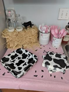 a table topped with cow themed plates and utensils