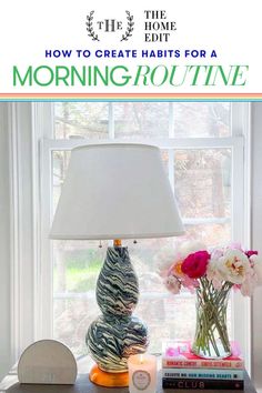 a lamp sitting on top of a table next to a vase with flowers in it