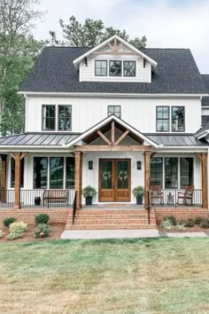 a large white house with lots of windows on the front and side of it's porch