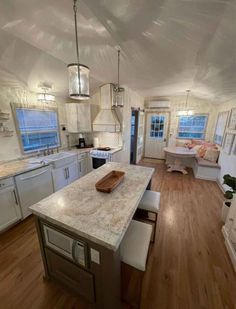 a large kitchen with white cabinets and wood flooring is seen in this image from the living room