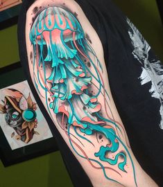 a man's arm with an octopus and jellyfish tattoo design on the left upper arm