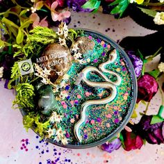 a bowl filled with green and purple sprinkles on top of a table