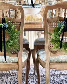 two chairs with wreaths on them sit in front of a table