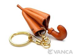 an orange umbrella shaped keychain is shown with a gold caramel colored handle