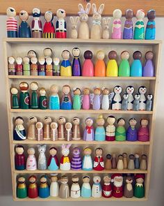 a wooden shelf filled with lots of different types of dolls