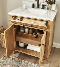 a bathroom sink sitting under a mirror on top of a wooden cabinet next to a rug