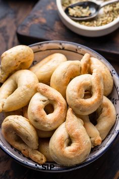 a bowl filled with doughnuts on top of a wooden table