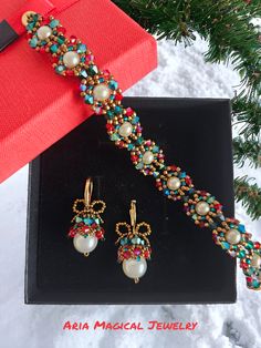 a bracelet and earring set sitting on top of a box next to a christmas tree