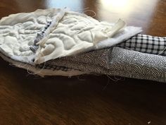 two pieces of fabric sitting on top of a wooden table