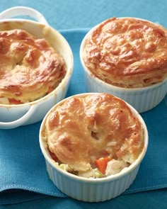 three small pies sitting on top of a blue cloth