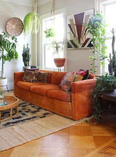 a living room filled with furniture and lots of potted plants on top of it