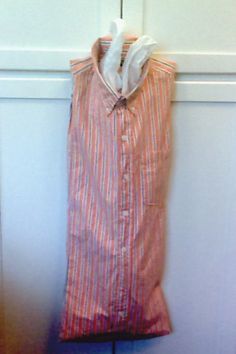 an orange and white shirt hanging on a wall next to a wooden door with a piece of paper sticking out of it