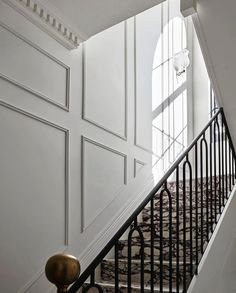 the stairs are lined with black iron railings and handrails, leading up to an arched window