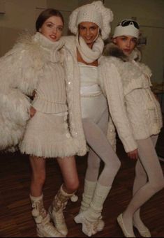 three women in white outfits posing for the camera